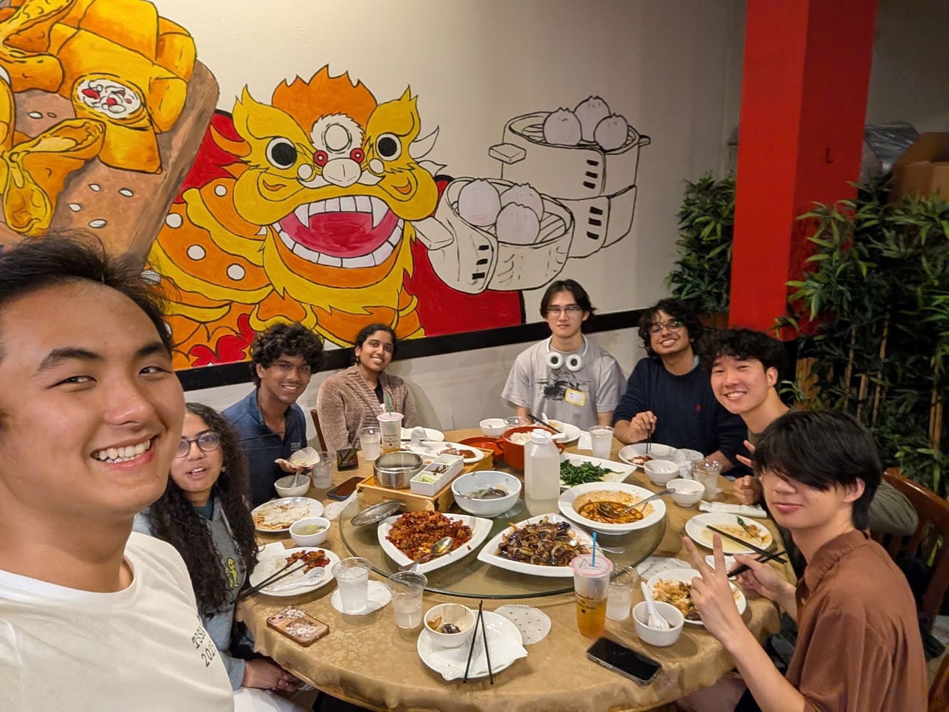 Friends around a round table full of Chinese food