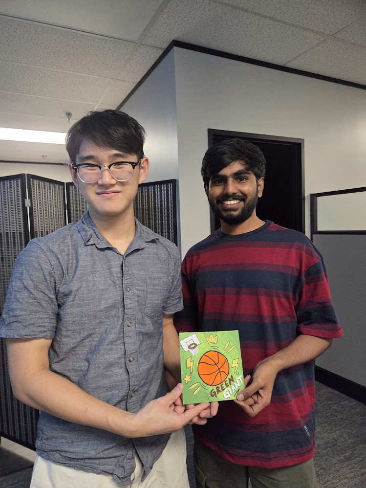 Feifan and Rohith holding a hand-drawn Green Giant basketball card